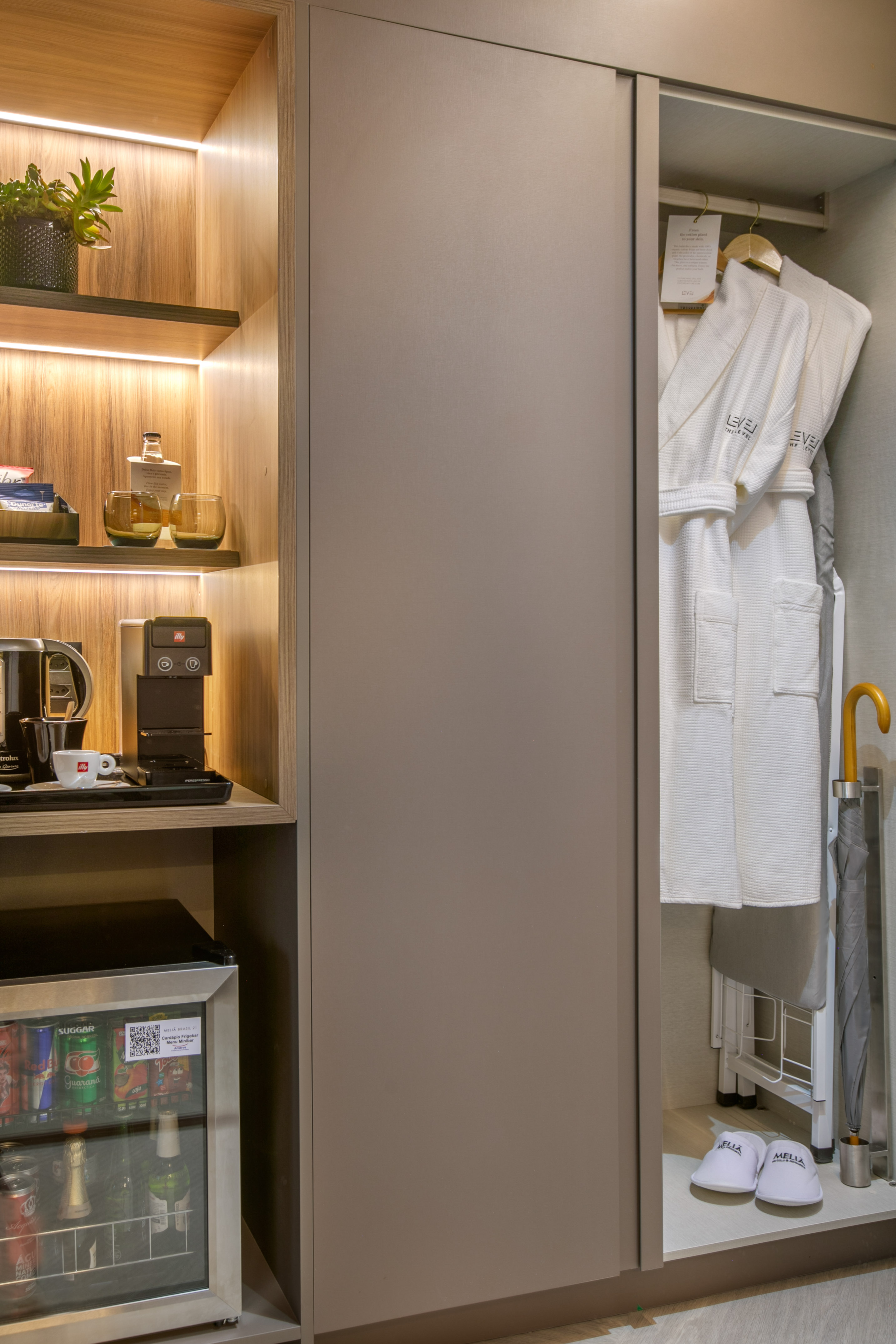 Hotel room minibar, coffee station, and wardrobe with bathrobes, slippers.