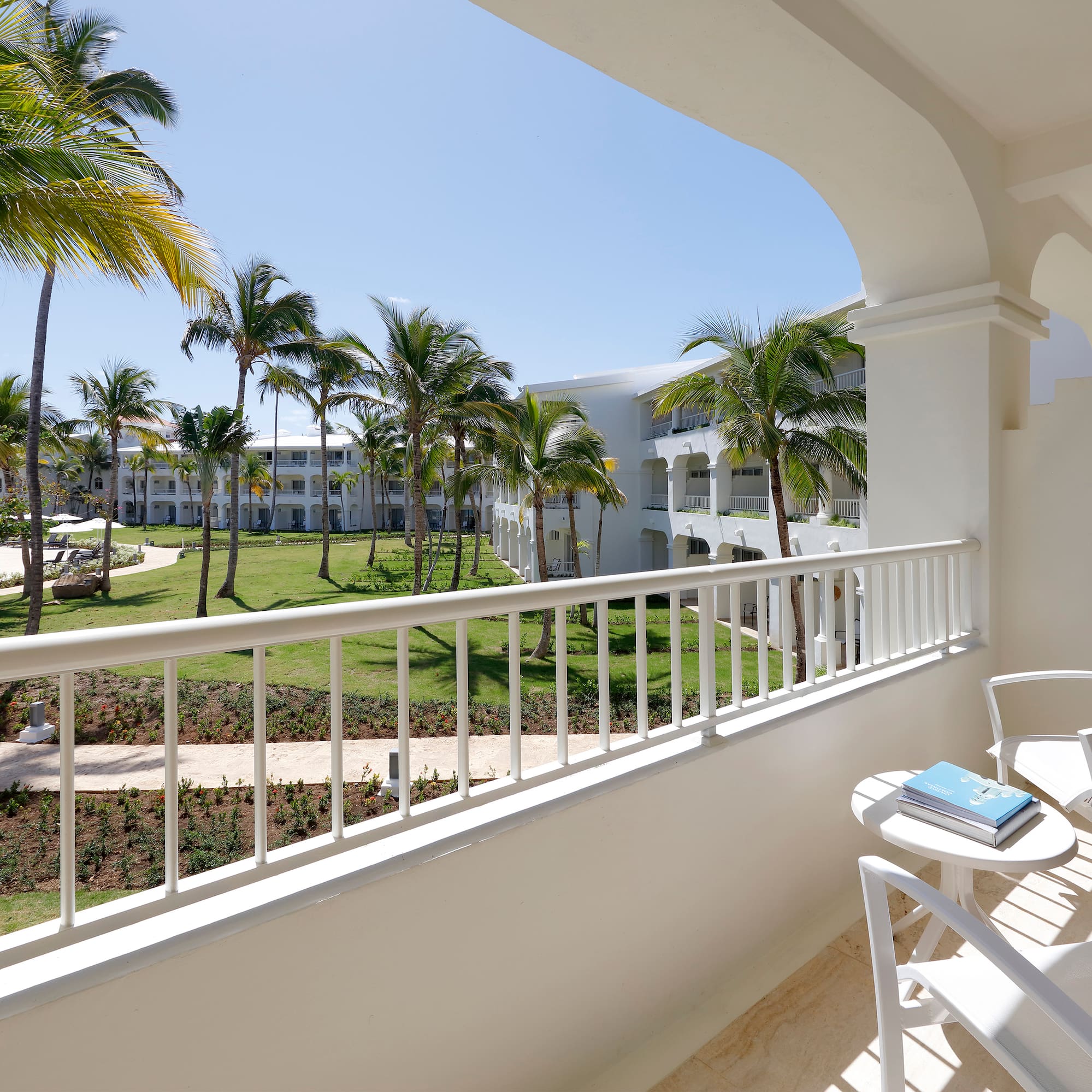 a balcony with a table and chairs and palm trees