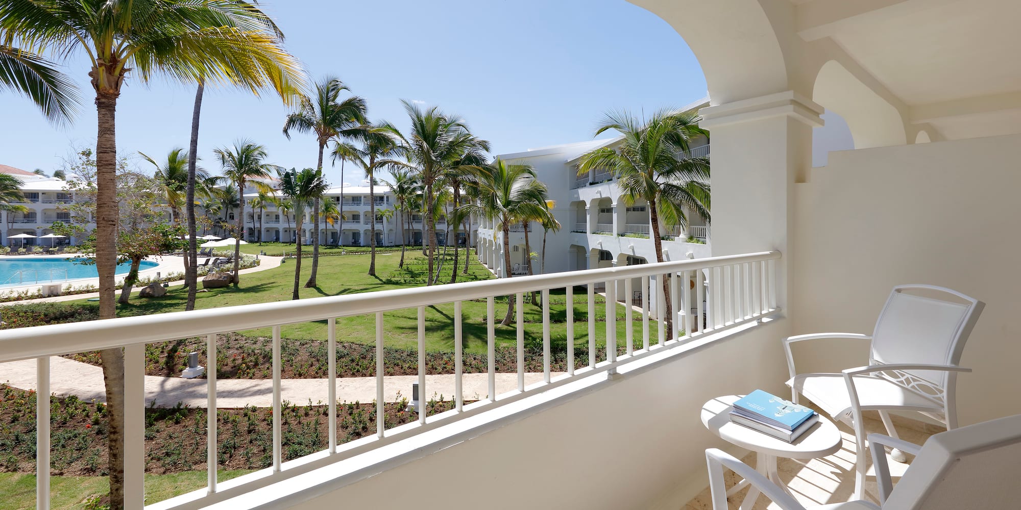 a balcony with a table and chairs and palm trees
