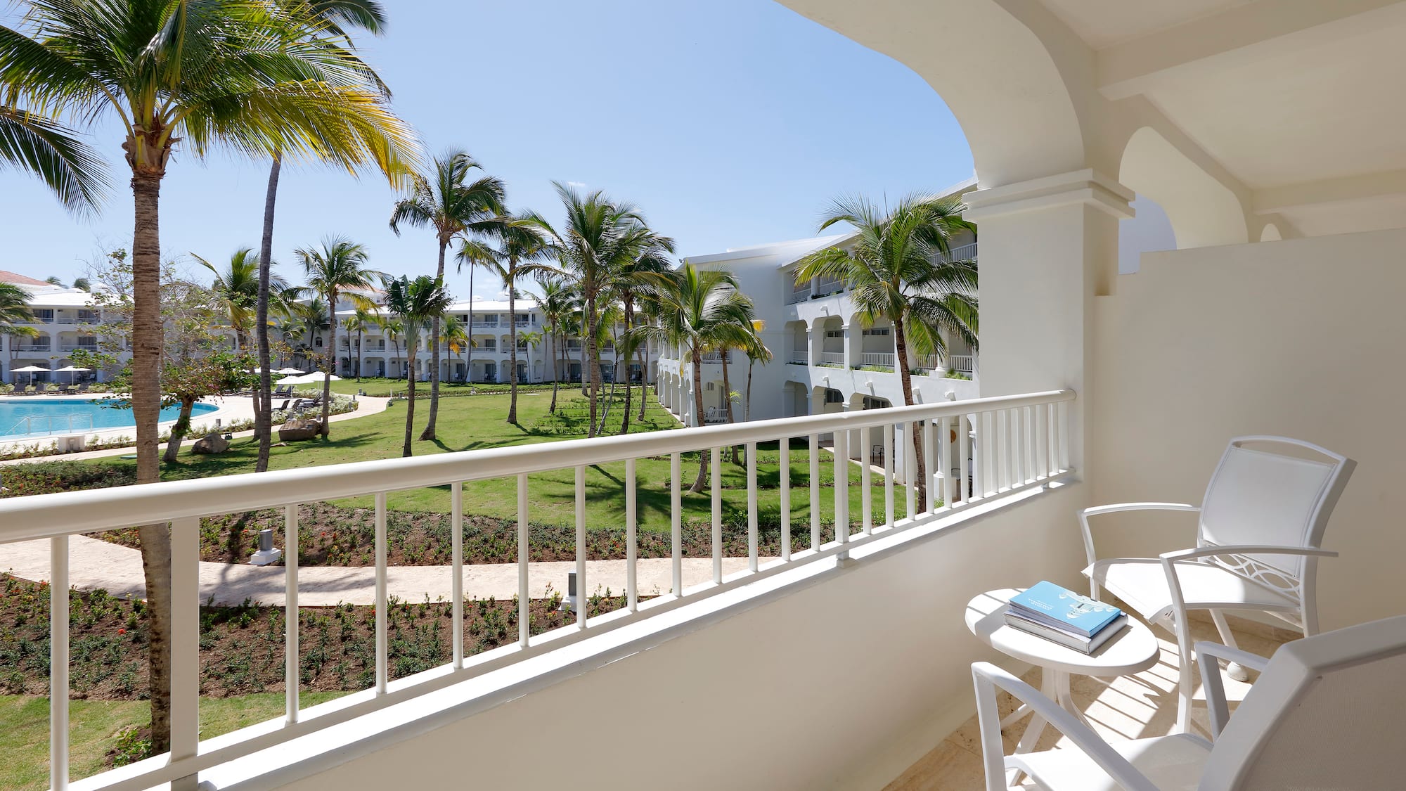 a balcony with a table and chairs and palm trees