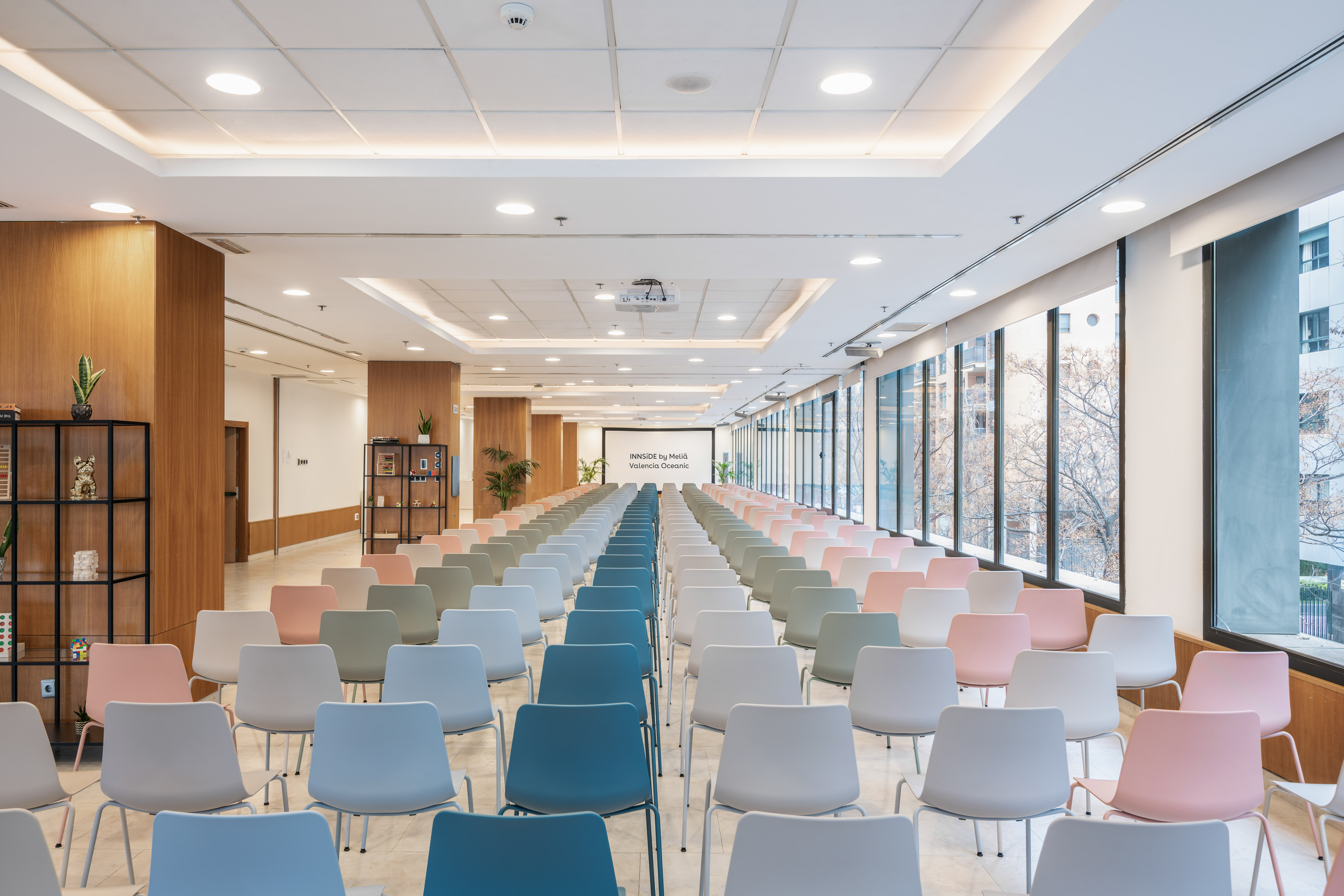 INNSiDE by Meliá Valencia Oceanic meeting room with colorful chairs and screen.