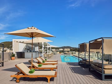 a pool with lounge chairs and umbrellas