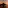 Sunset over ocean with dark rocky island silhouette, reflecting orange sky.