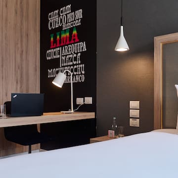 a room with a bed and a laptop