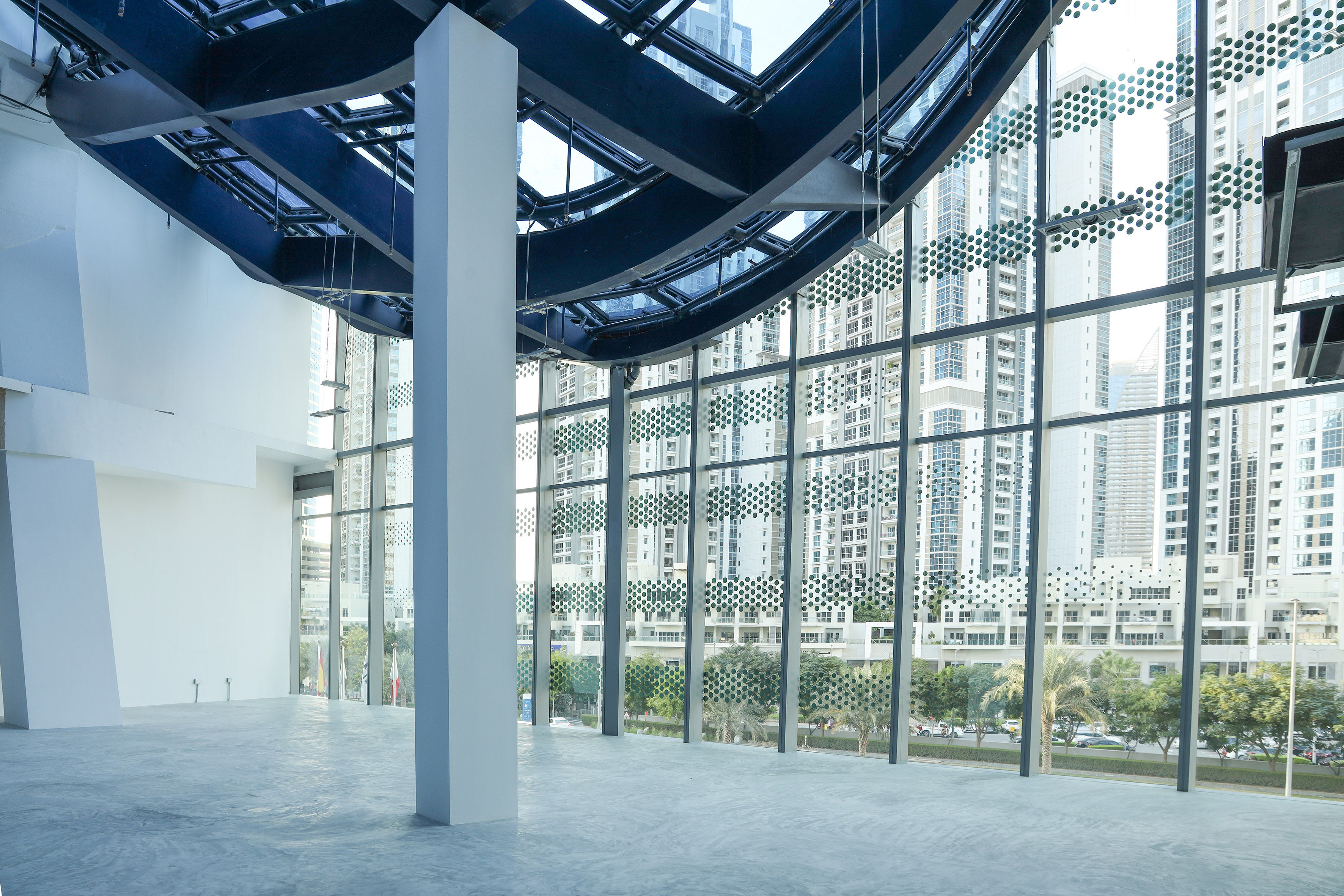 Empty modern commercial interior, large patterned windows, city skyline.