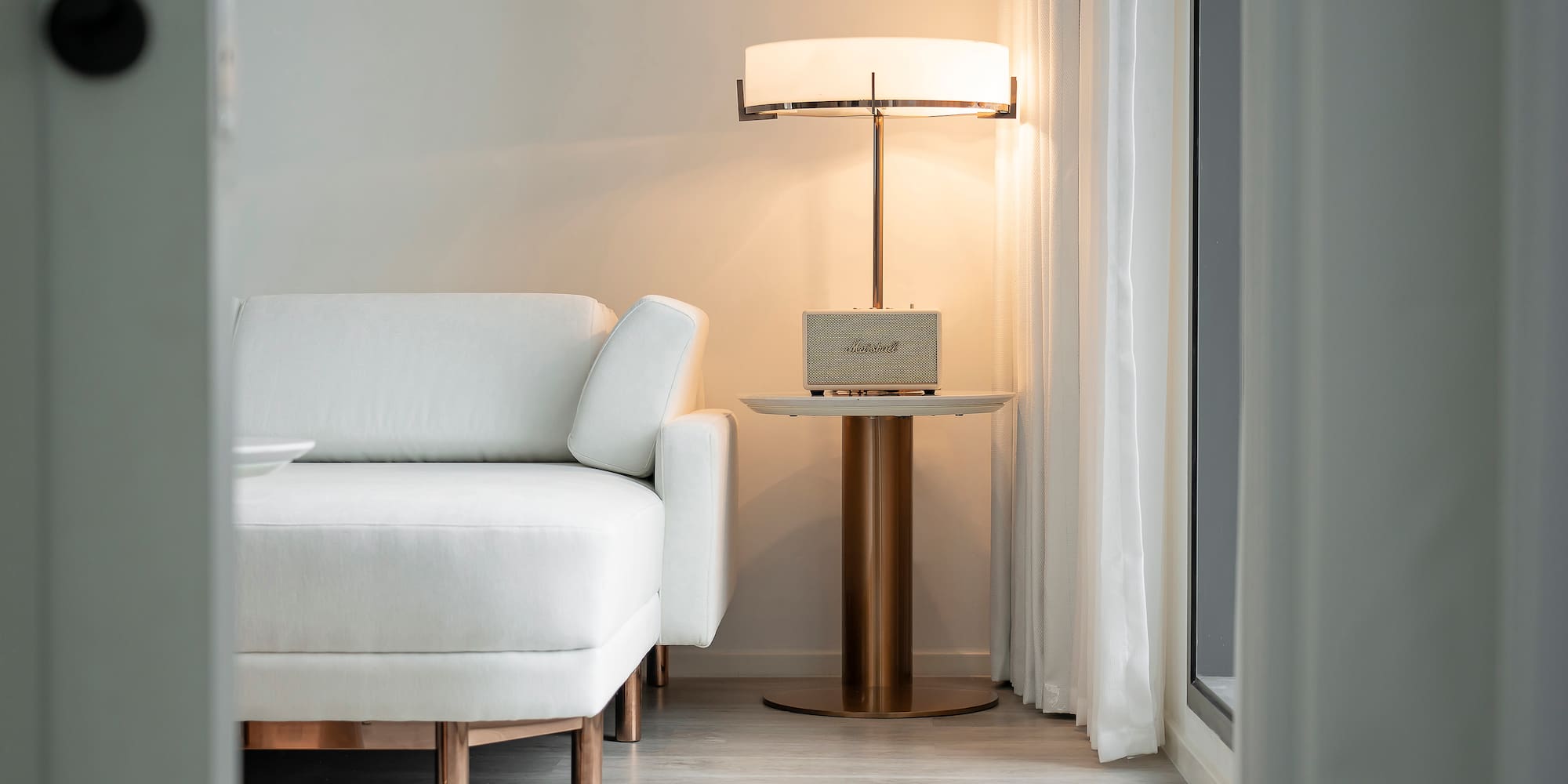 a white couch with a lamp next to a table