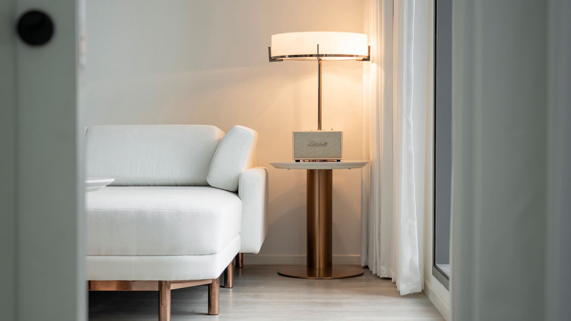 a white couch with a lamp next to a table