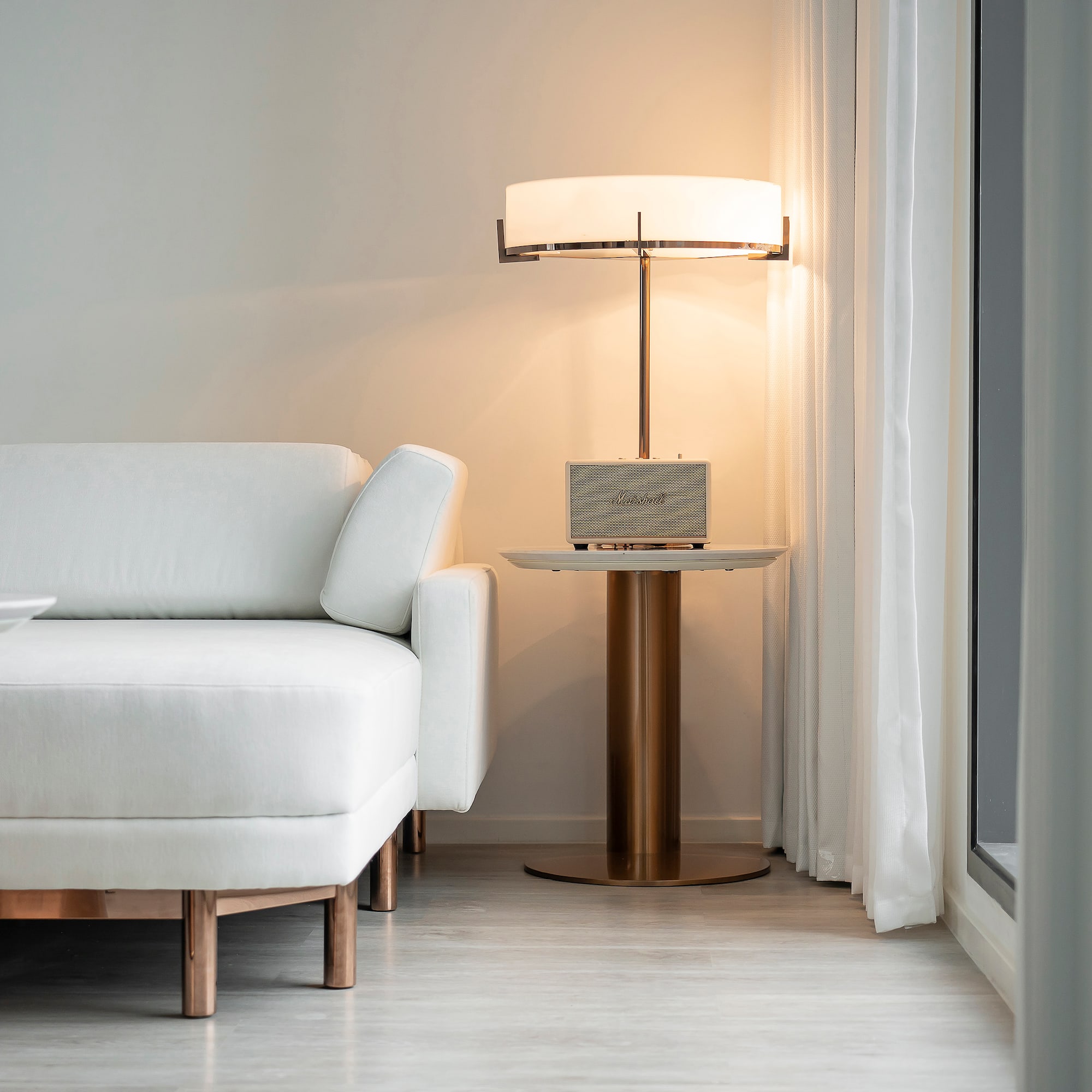 a white couch with a lamp next to a table