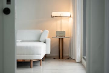 a white couch with a lamp next to a table