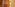 Wooden hotel wardrobe with built-in safe, minibar, drawers, and white bathrobe.