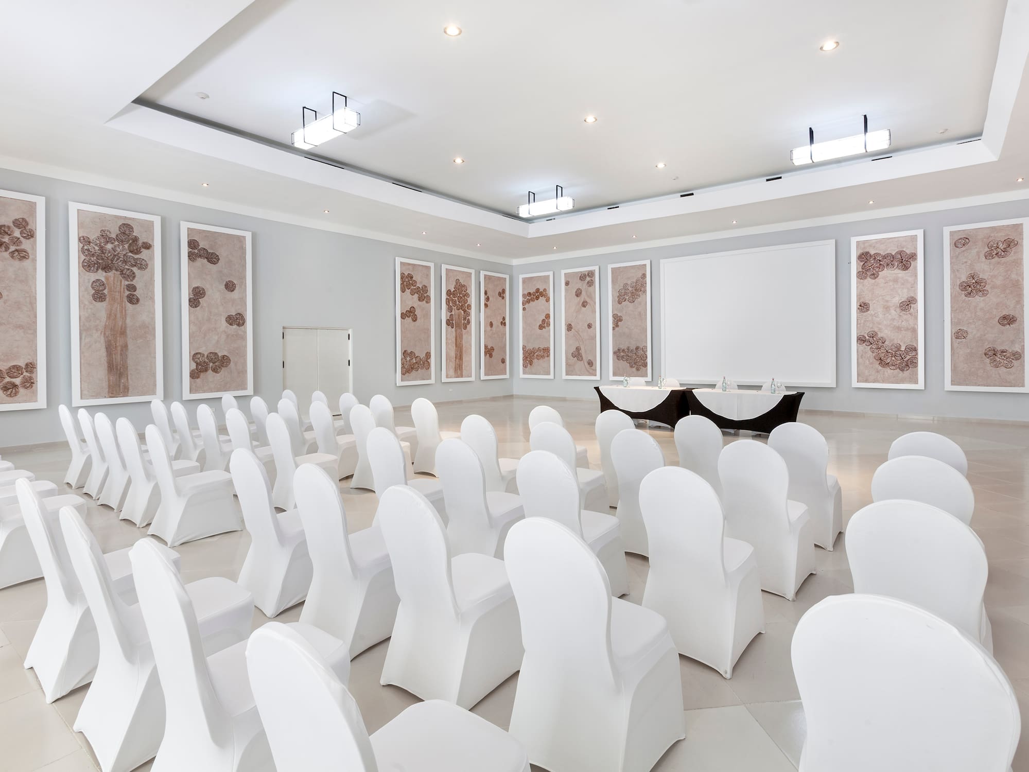 a room with white chairs and a table