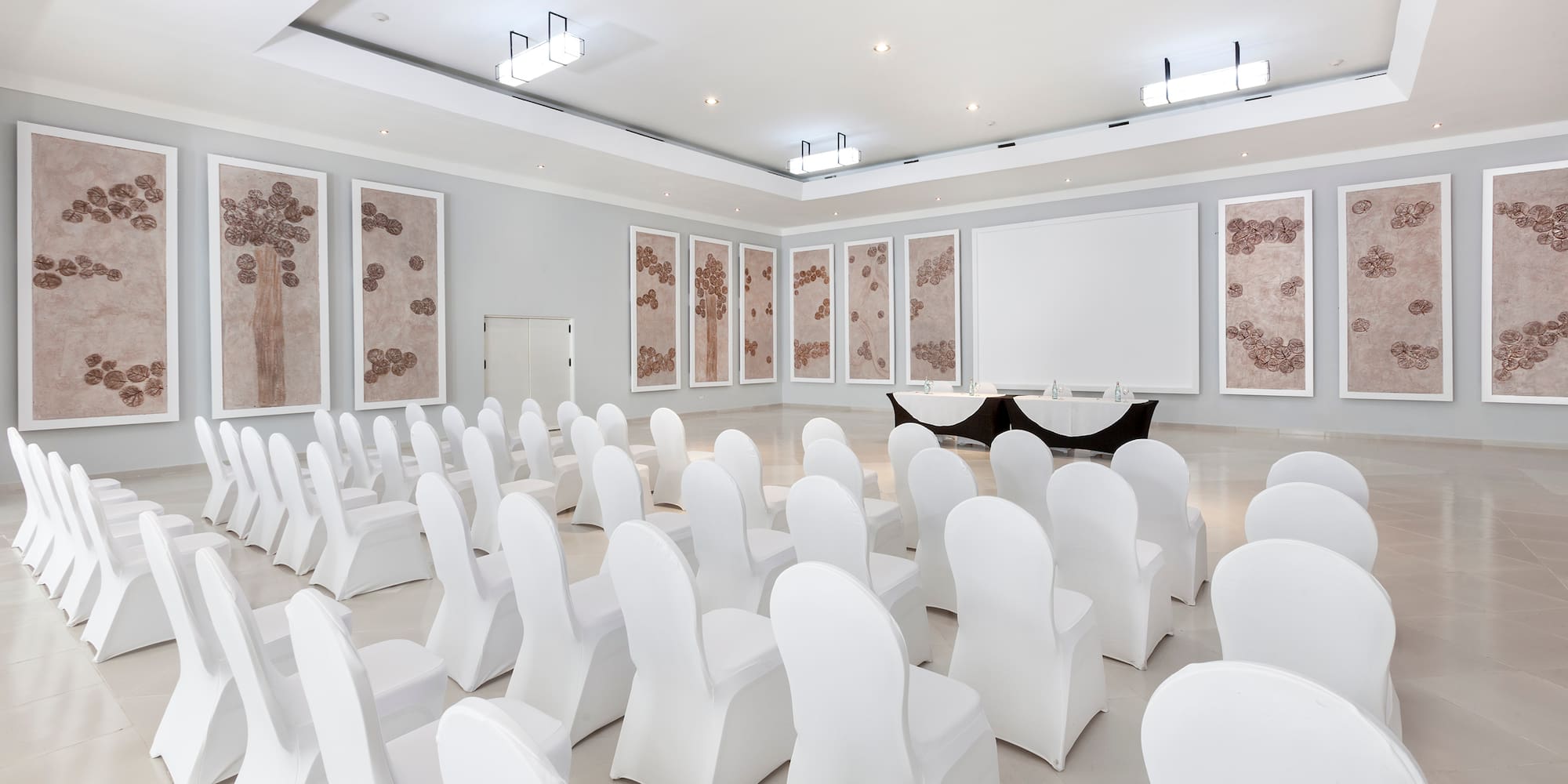 a room with white chairs and a table