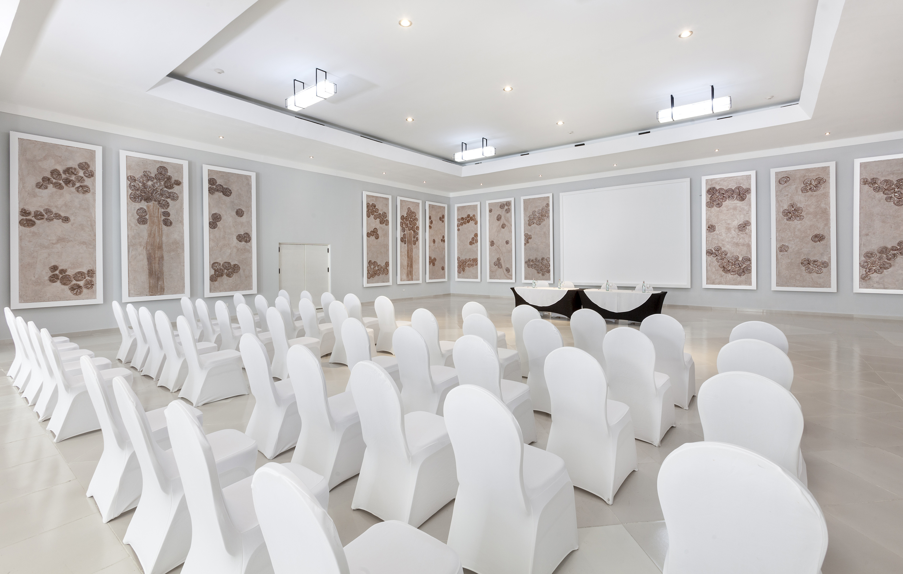 a room with white chairs and a table