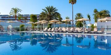 a pool with lounge chairs and umbrellas