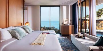 a bedroom with a large bed and a view of the ocean