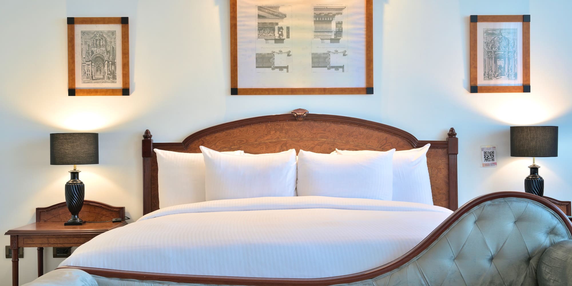 a bed with white sheets and pillows