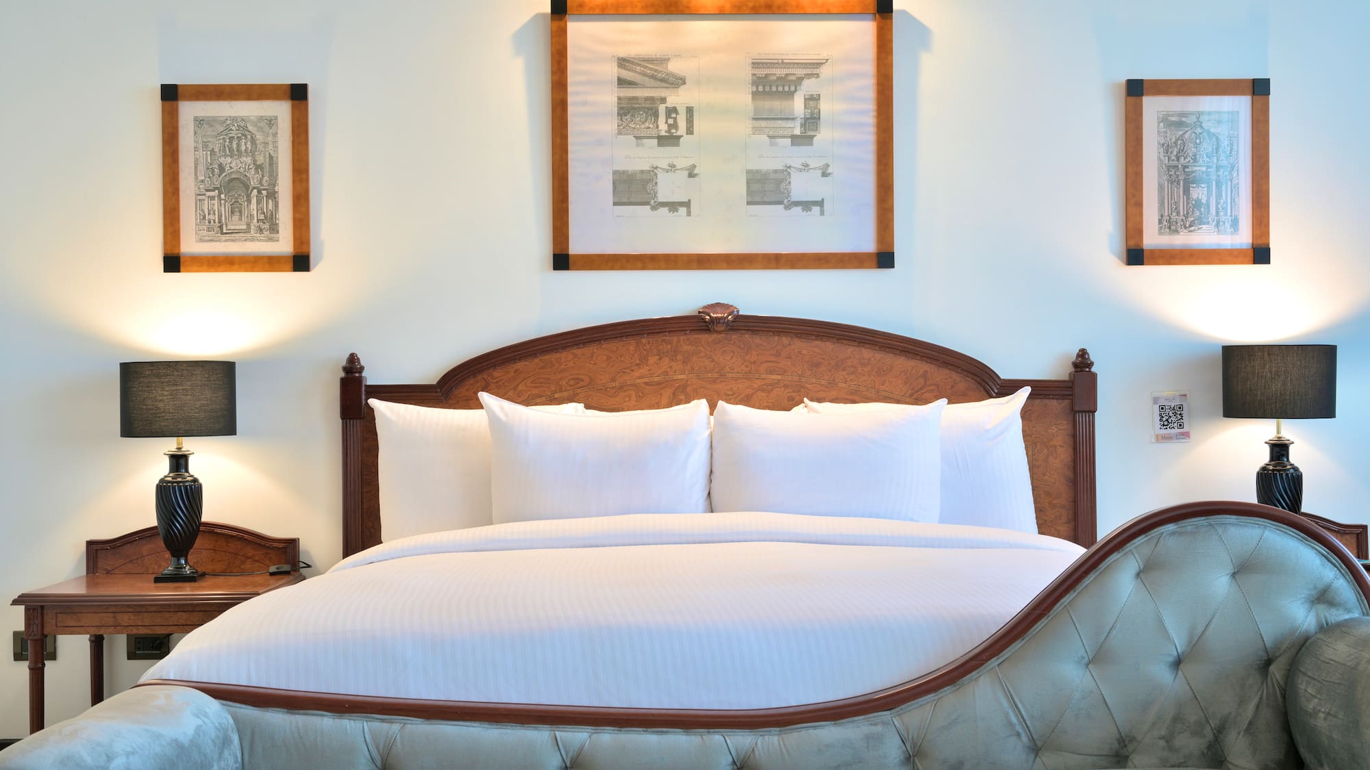 a bed with white sheets and pillows