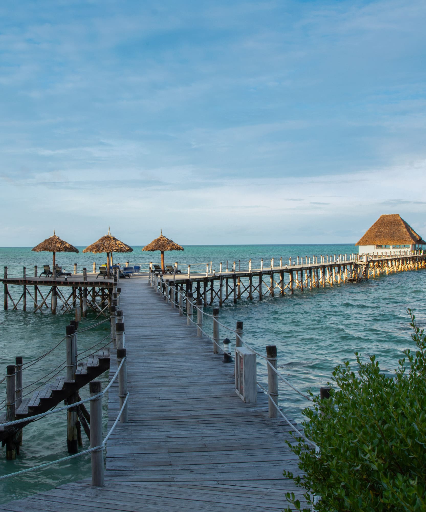 a dock with straw umbrellas on it