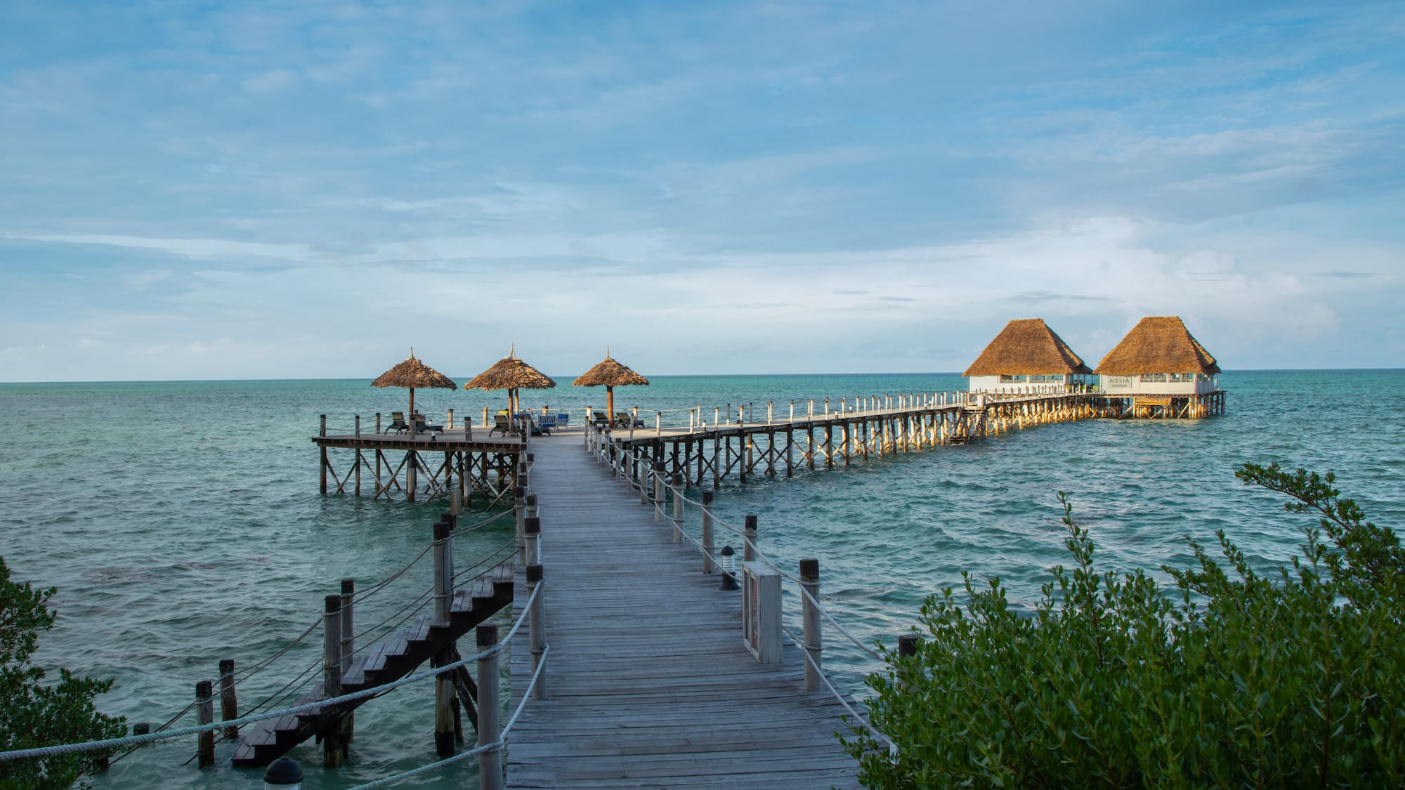 a dock with straw umbrellas on it