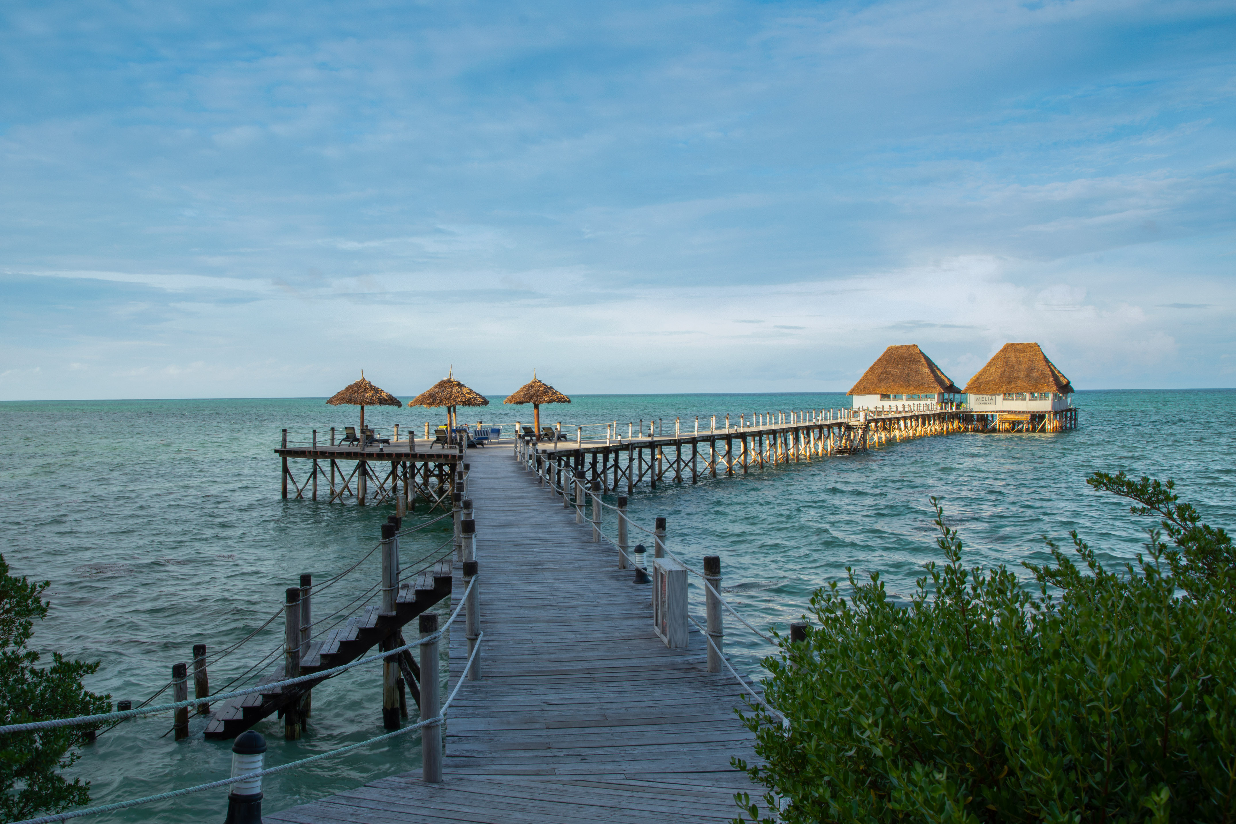 a dock with straw umbrellas on it