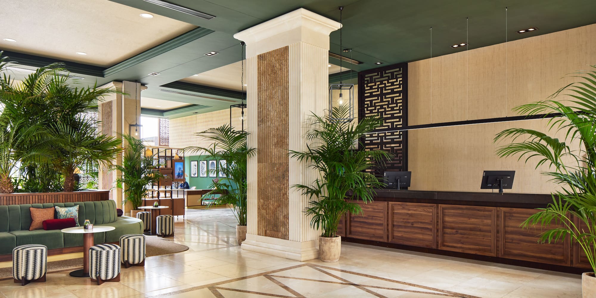 a lobby with a reception desk and palm trees