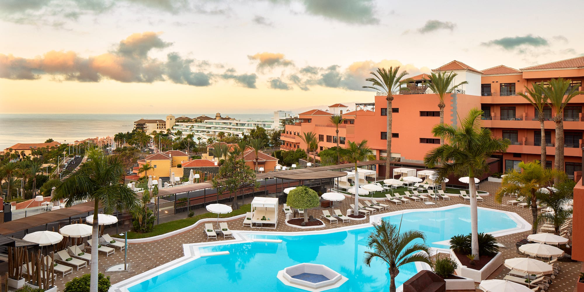a pool with palm trees and a building in the background
