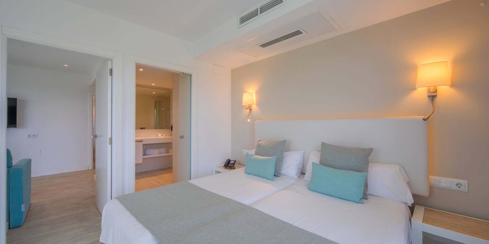 a bed with pillows and a mirror in the background