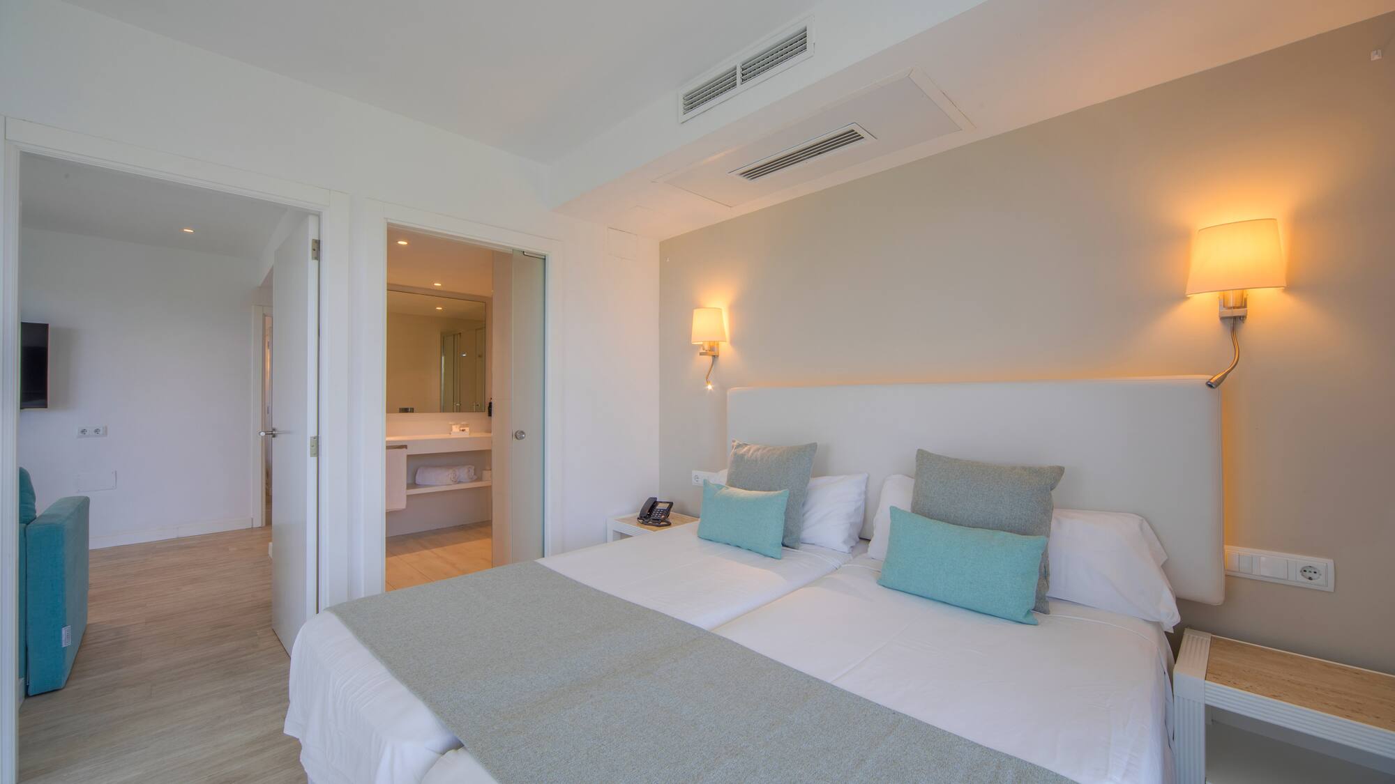 a bed with pillows and a mirror in the background