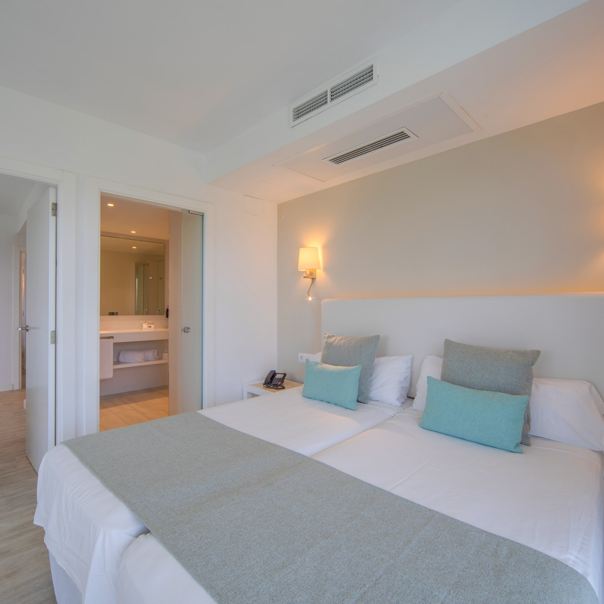 a bed with pillows and a mirror in the background