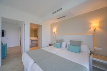 a bed with pillows and a mirror in the background