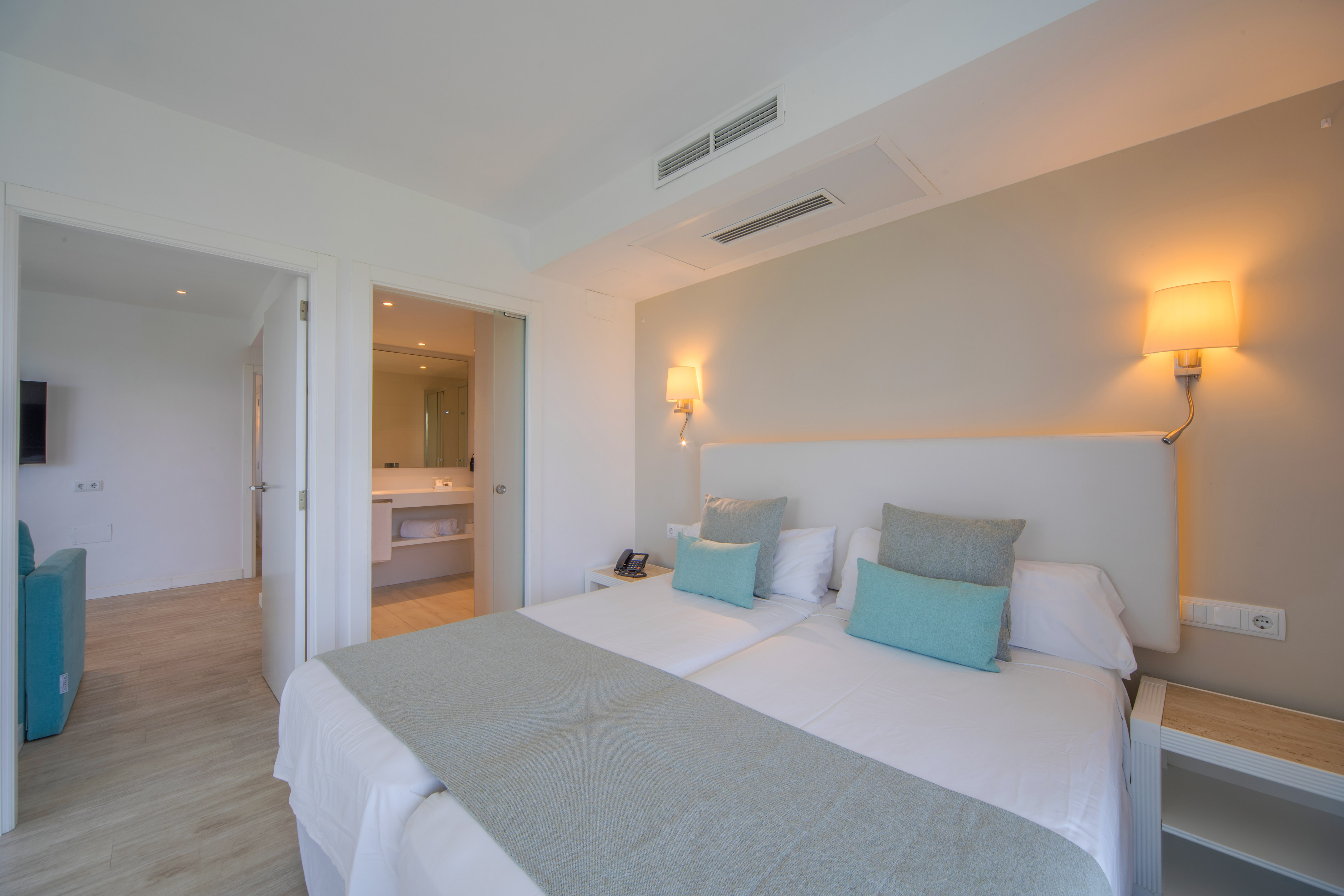 a bed with pillows and a mirror in the background