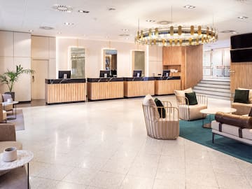 a lobby with a chandelier and chairs