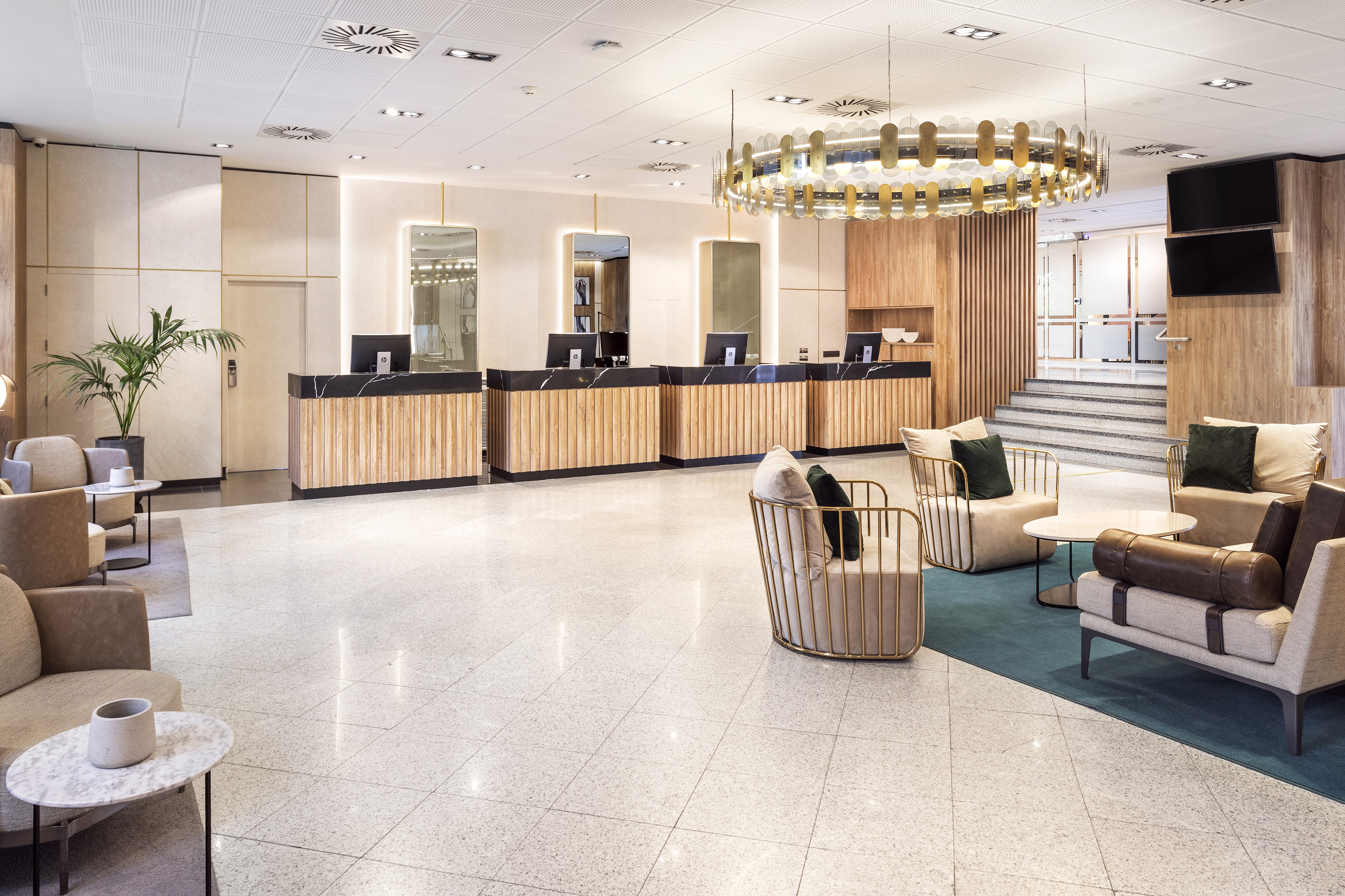 Modern hotel lobby with wood reception desks and comfortable guest seating.