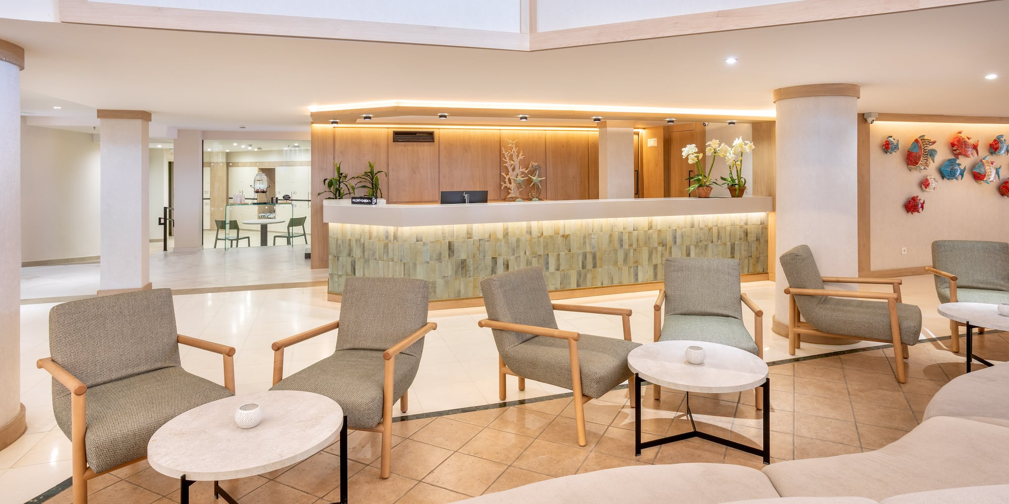 Modern hotel lobby with bright reception desk and comfortable lounge seating.
