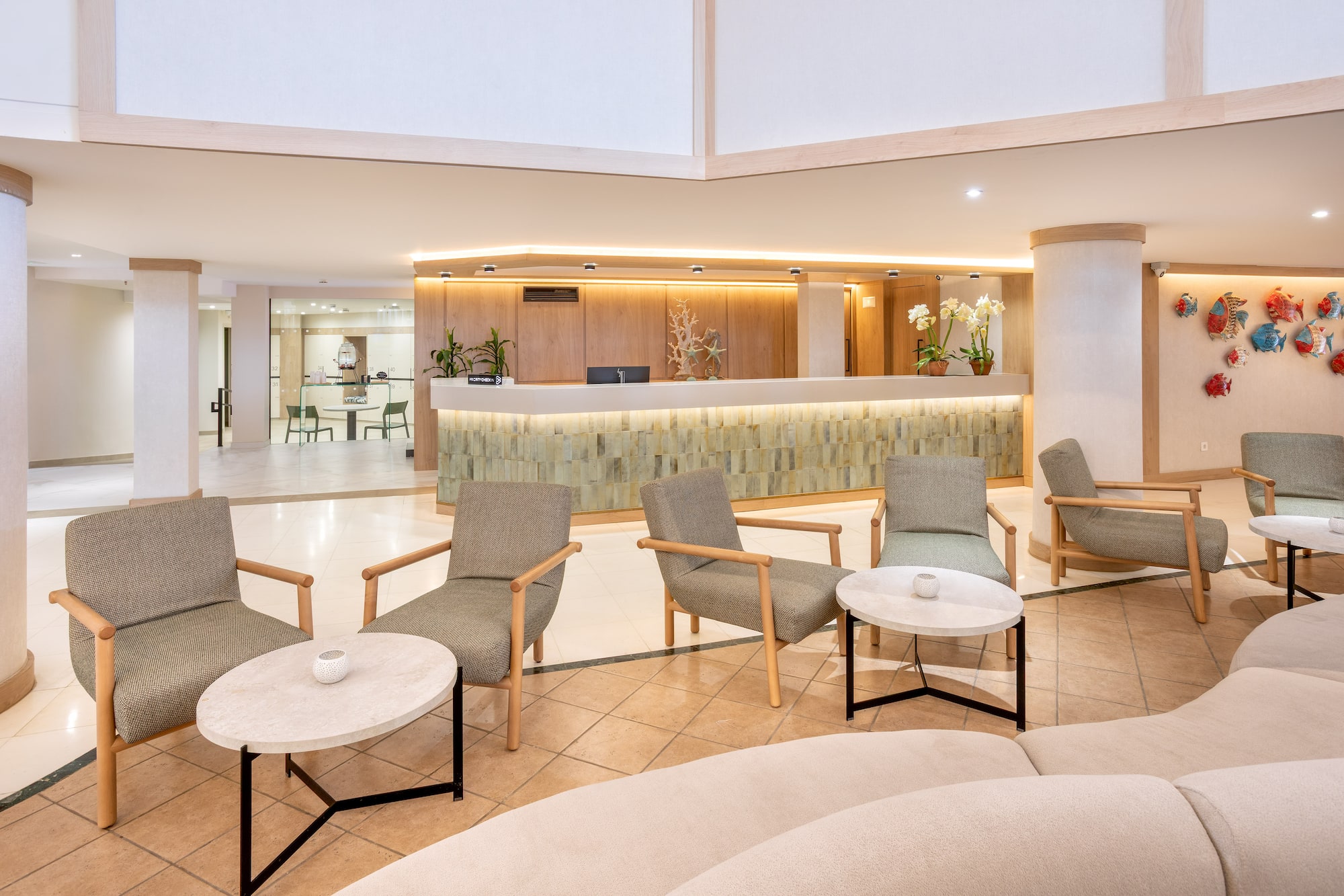 Modern hotel lobby with welcoming reception desk, fish art, and comfortable guest seating.