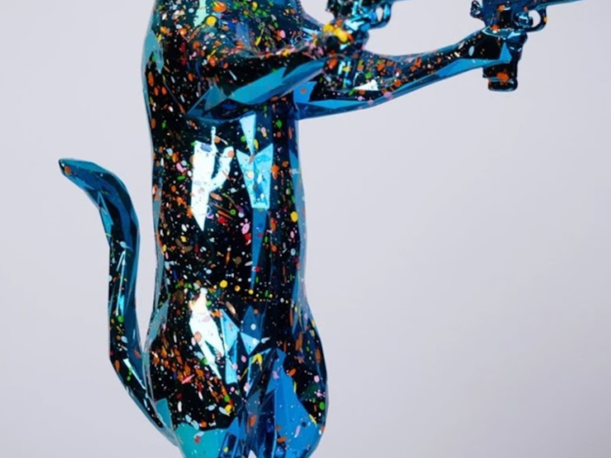 a statue of a cat holding guns