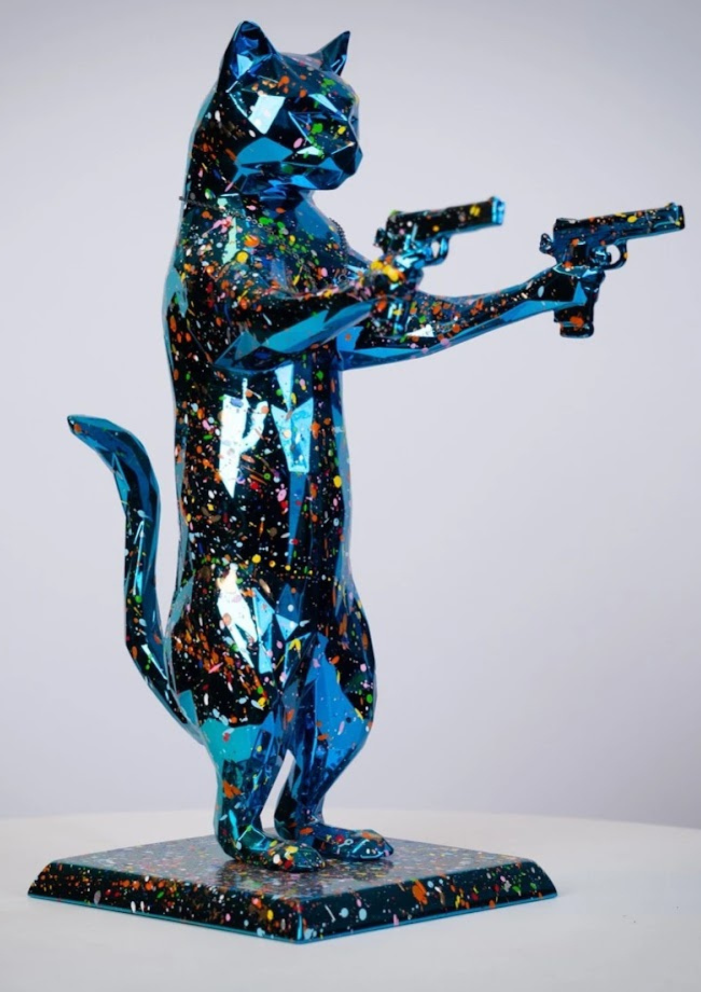 a statue of a cat holding guns