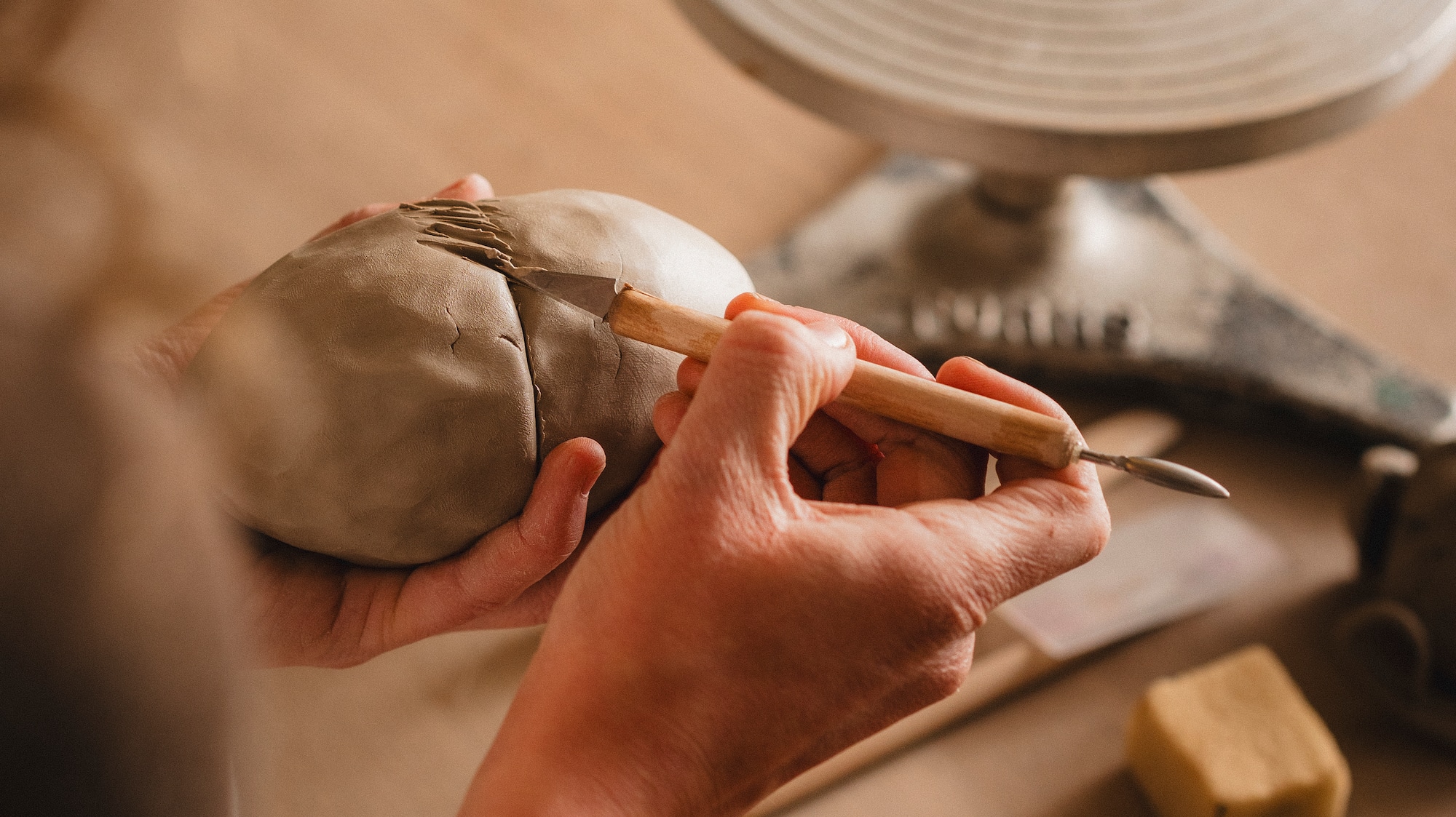 a person using a tool to sculpt a clay object