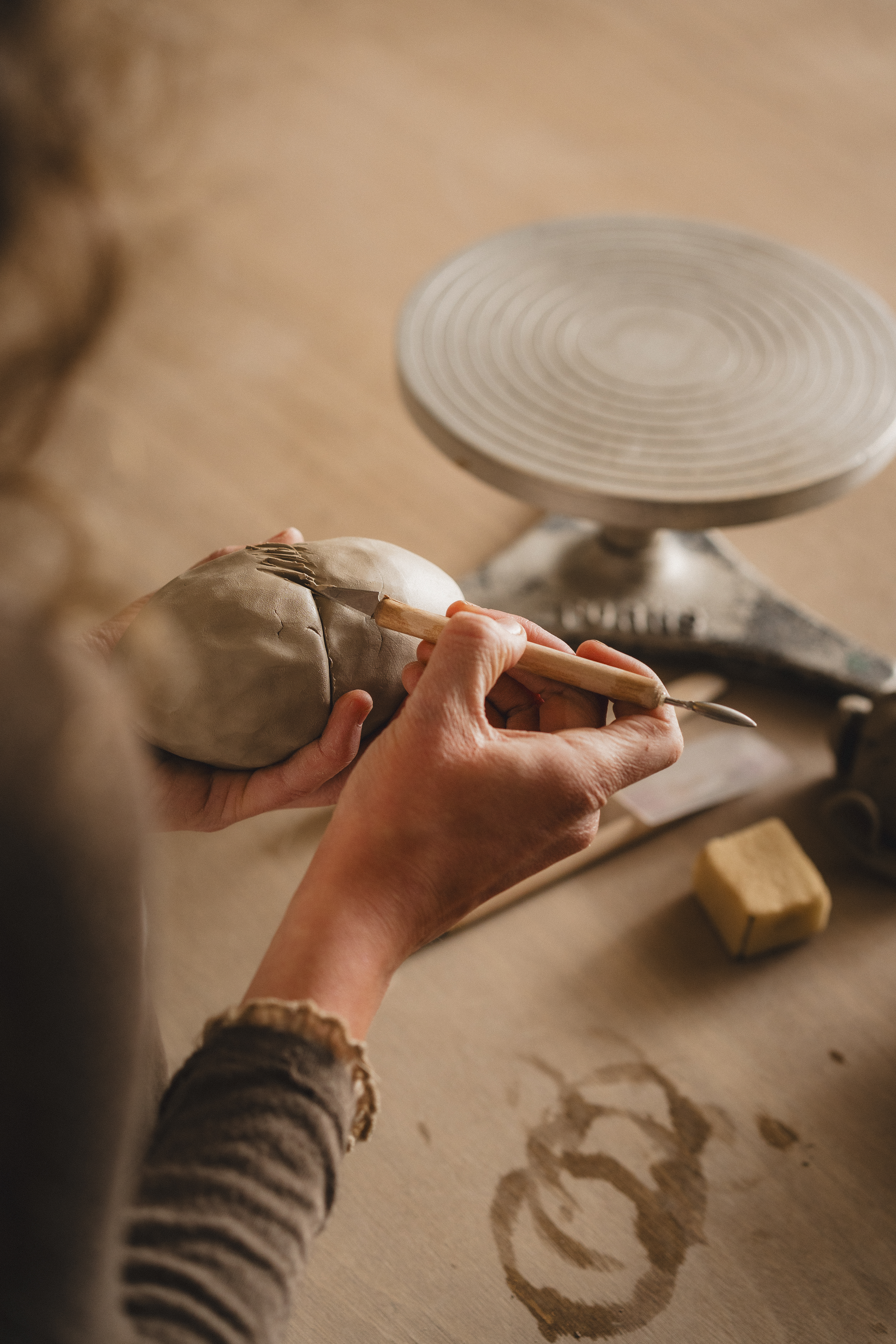 a person using a tool to sculpt a clay object