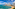 a beach with boats and buildings in the background