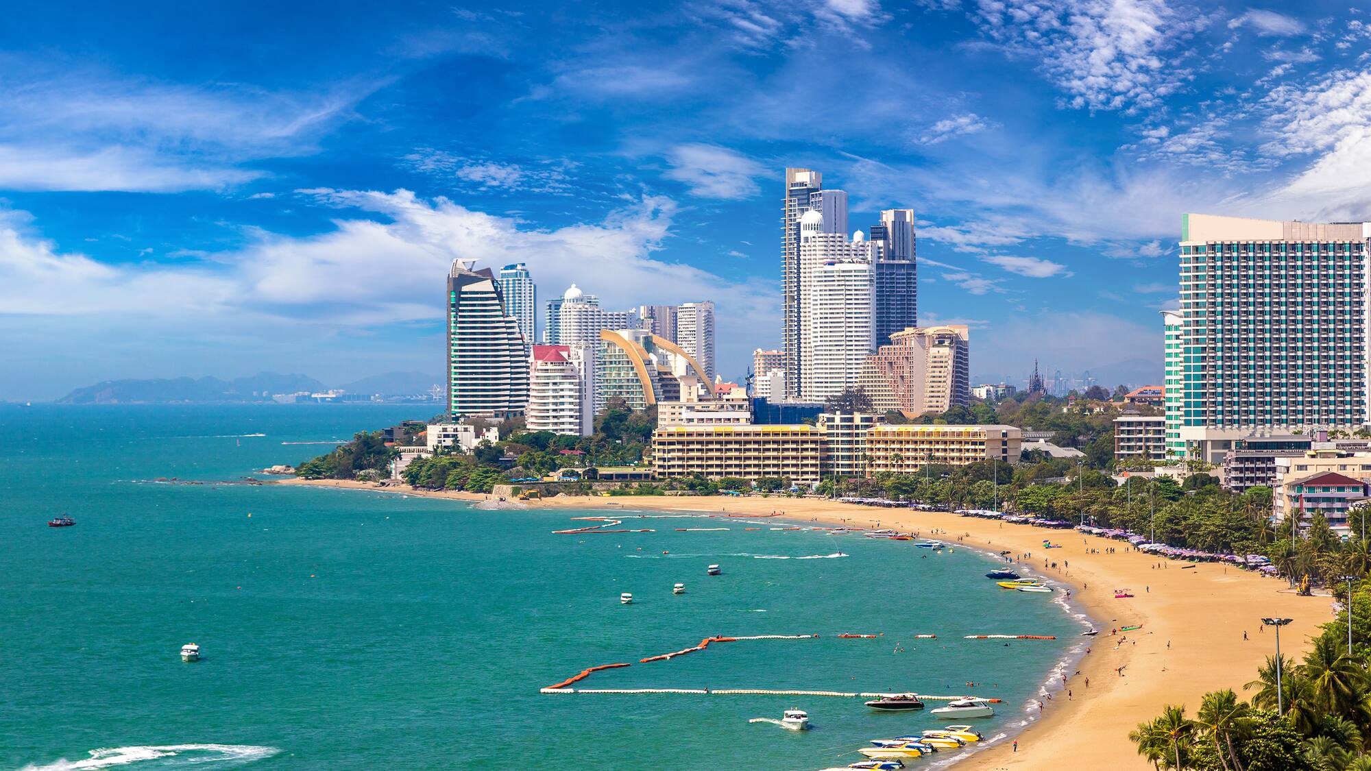a beach with boats and buildings in the background