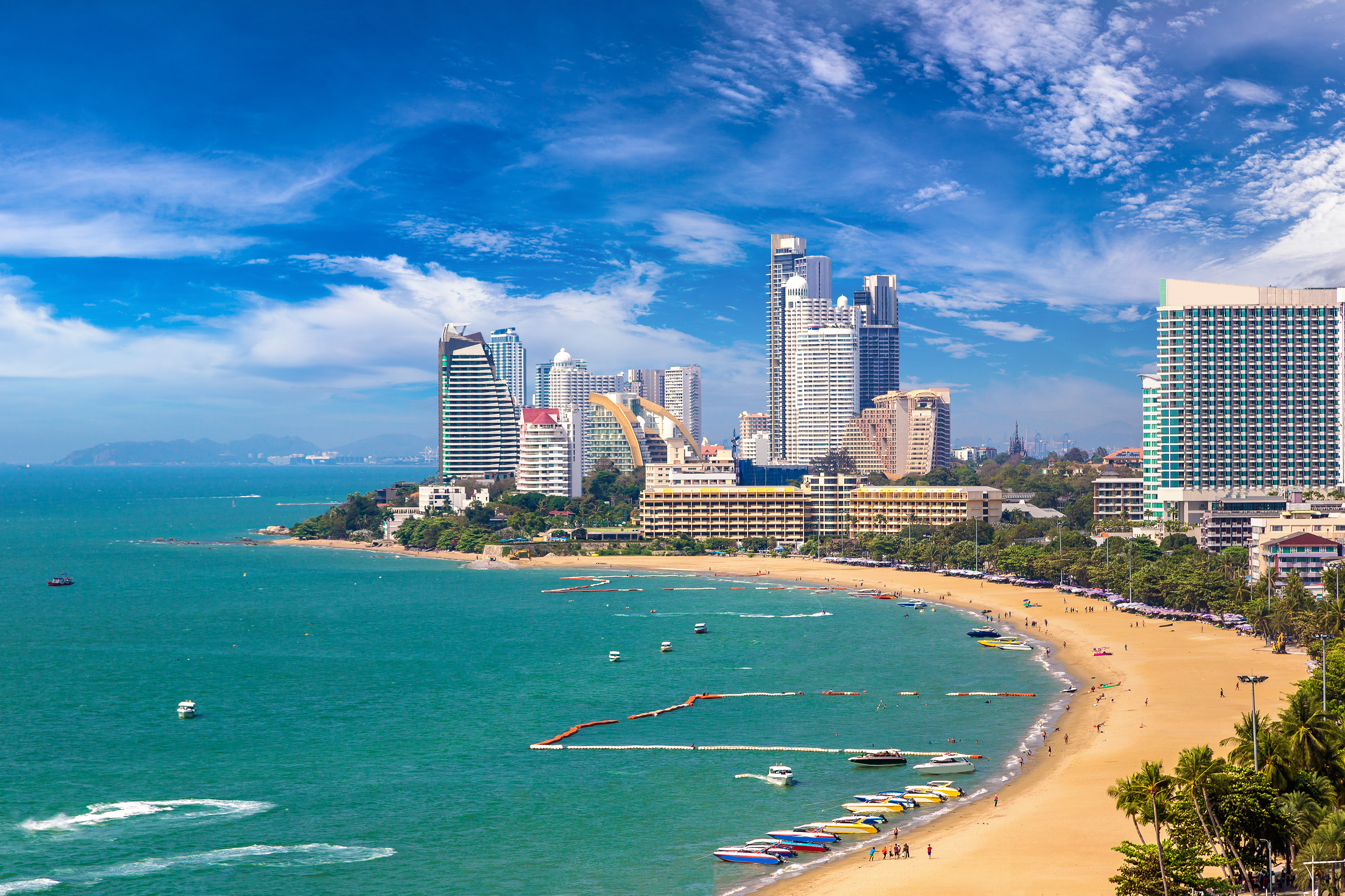 a beach with boats and buildings in the background