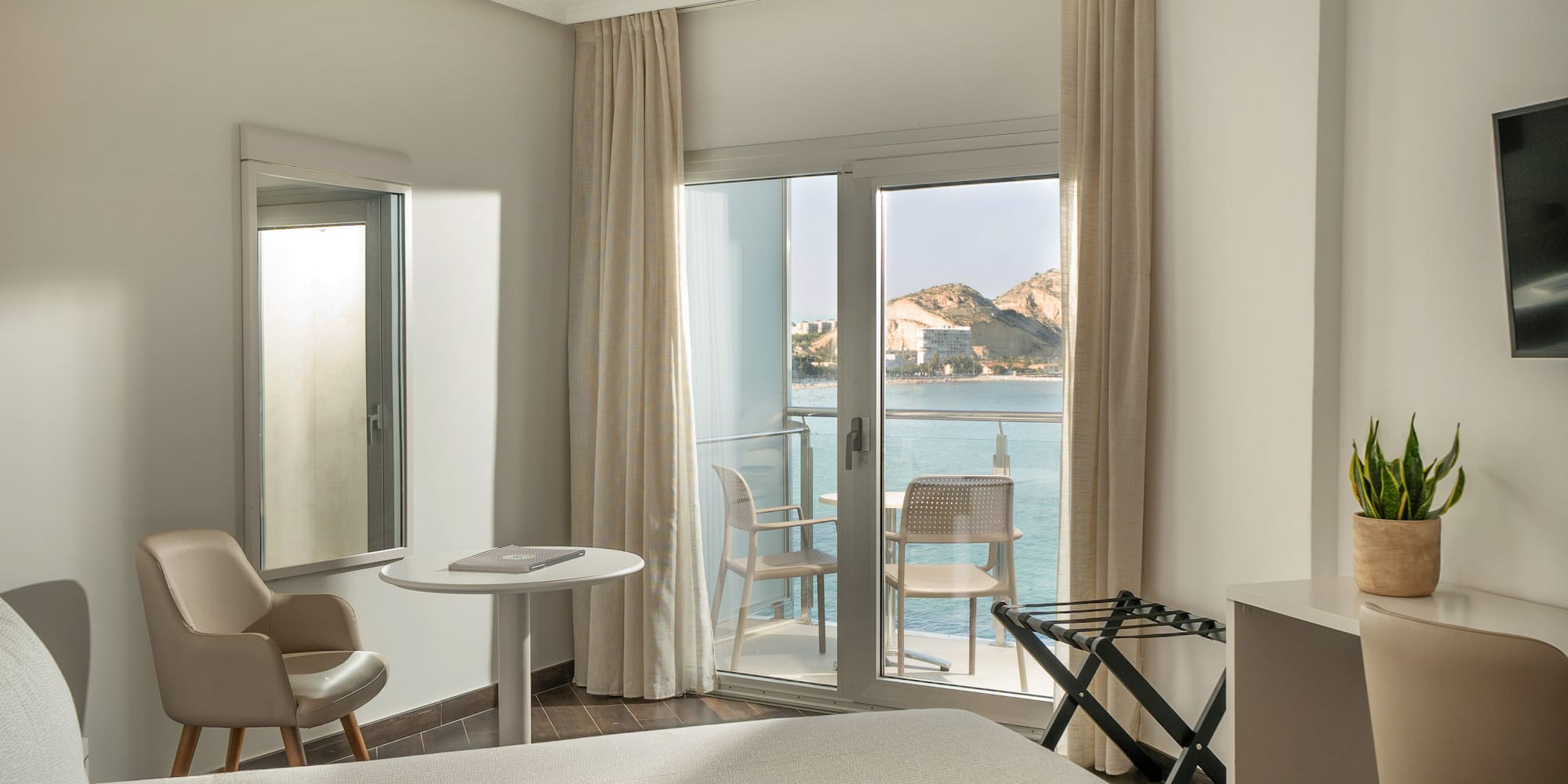 a room with a bed and chairs and a table and a door