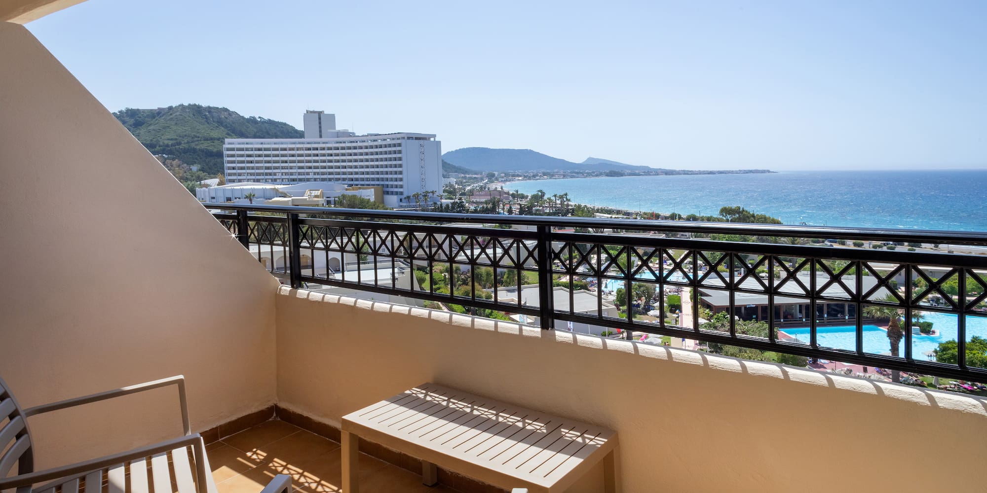 a balcony with chairs and a view of the ocean