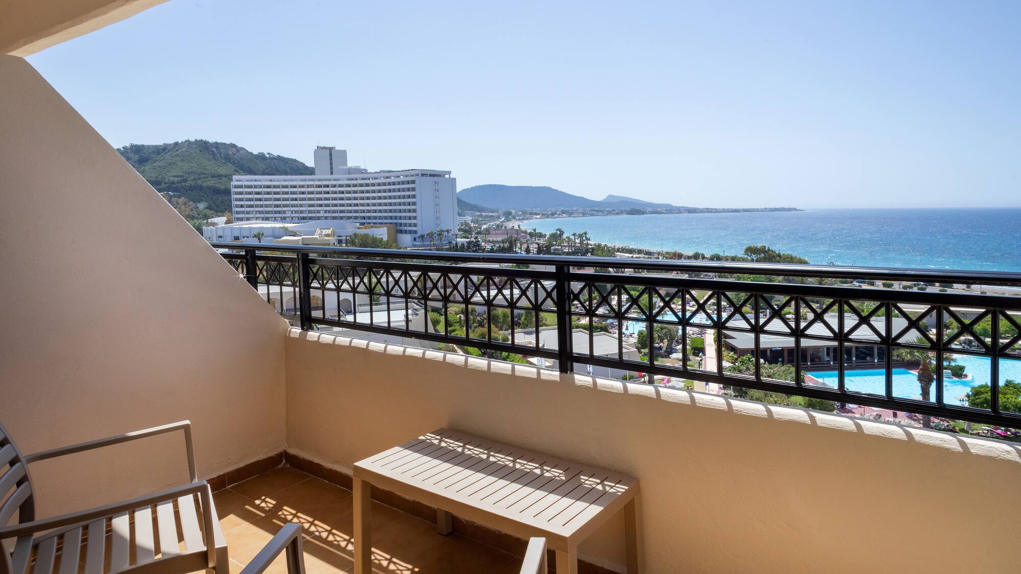 a balcony with chairs and a view of the ocean