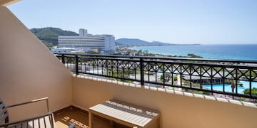 a balcony with chairs and a view of the ocean