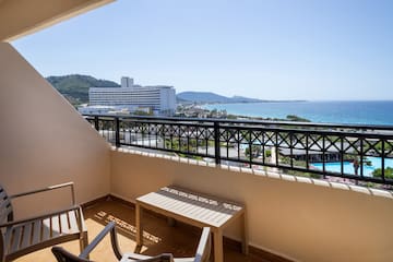 a balcony with chairs and a view of the ocean