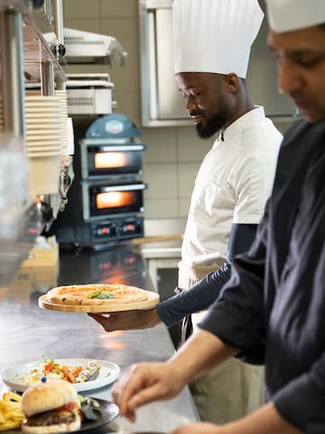 a chef holding a pizza