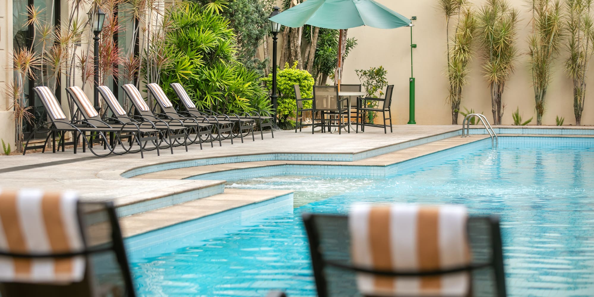 a pool with chairs and umbrellas