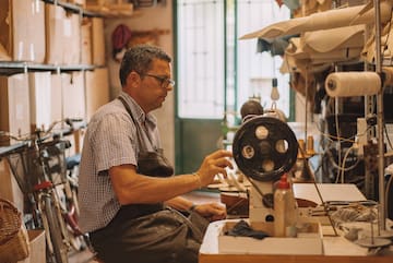 a man sitting at a sewing machine